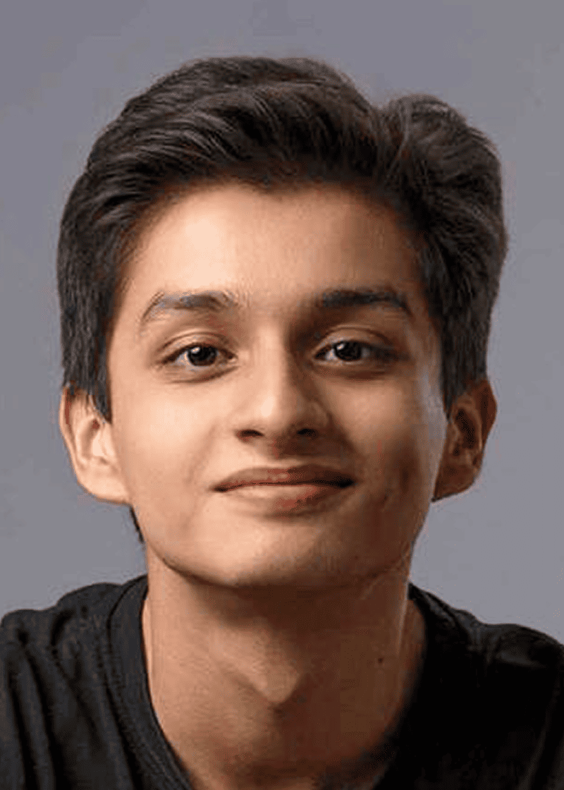 Benjamin Illescas A young man with short, dark hair and a slight smile wears a black shirt against a gray background.